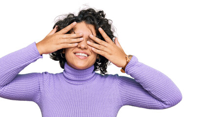 Young hispanic woman with curly hair wearing casual clothes covering eyes with hands smiling cheerful and funny. blind concept.
