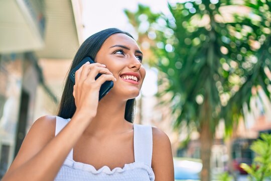 Young latin girl smiling happy talking on the smartphone at street of city.