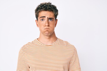 Obraz premium Young handsome man wearing casual clothes puffing cheeks with funny face. mouth inflated with air, crazy expression.