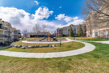 Obraz premium Colorful playground amidst apartment homes and walkways in scenic neighborhood