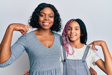 Beautiful african american mother and daughter wearing casual clothes and hugging looking confident with smile on face, pointing oneself with fingers proud and happy.