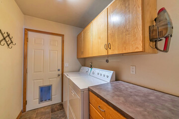 Small and functional residential laundry room with tiled floor and appliances
