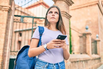 Young middle east student girl with serious expression using smartphone at the university campus.