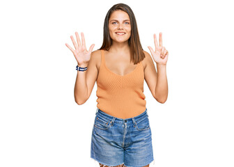 Obraz na płótnie Canvas Young caucasian woman wearing casual clothes showing and pointing up with fingers number eight while smiling confident and happy.