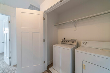 Small room inside a residential house with washing machine and dryer appliances
