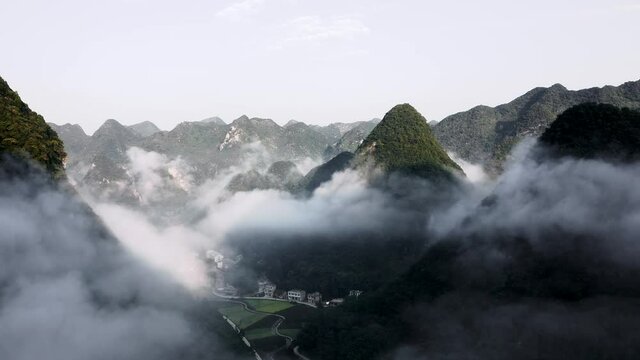 Aerial: amazing cloudy karst mountain landscape in remote China