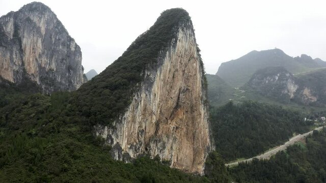 Dramatic karst mountain rock face in mountainous China valley, aerial view