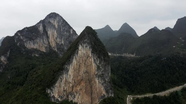 Asian karst mountains on overcast day, aerial arc shot