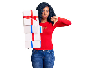 Beautiful african american woman holding presents with angry face, negative sign showing dislike...
