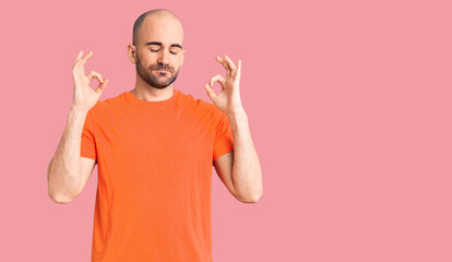 Young handsome man wering casual t shirt relax and smiling with eyes closed doing meditation gesture with fingers. yoga concept.