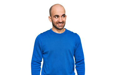 Young hispanic man wearing casual clothes looking away to side with smile on face, natural expression. laughing confident.