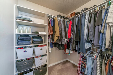 Interior of residential home walk in closet with built in open storage shelves