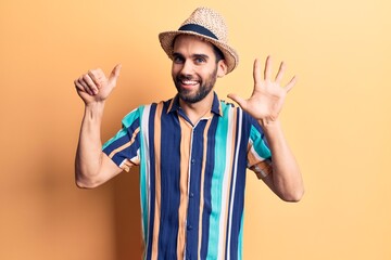 Young handsome man with beard wearing summer hat and shirt showing and pointing up with fingers number six while smiling confident and happy.