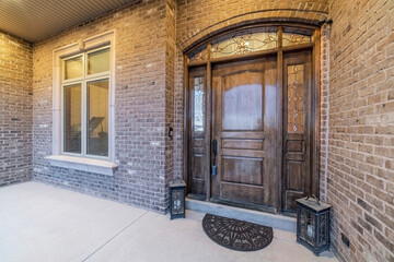 Beautiful facade of house with front door and window against stone brick wall