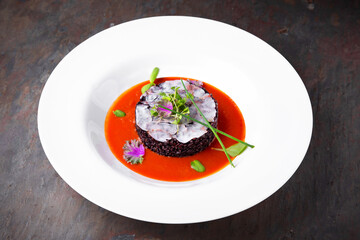 Risotto from black rice with fish in tomato sauce. Italian restaurant. Menu. Free space for text
