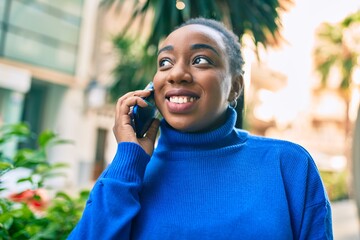 Young african american woman smiling happy talking on the smartphone at the city.