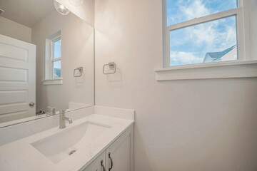 Interior of a small bathroom with white wall and single basin rectangular sink