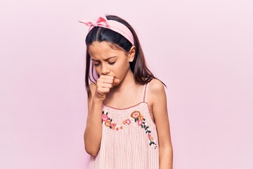 Beautiful child girl wearing casual clothes feeling unwell and coughing as symptom for cold or...