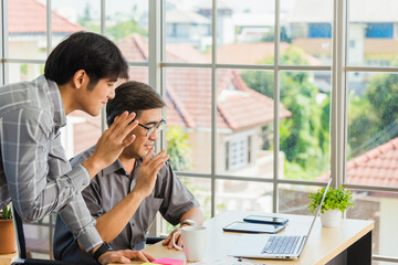 Asian senior and young business man working online on a modern laptop computer he looking the...