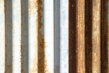 Rusted corrugated sheet metal siding background showing its age and weathering.