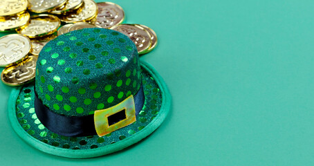 Close up of a St Patricks day Irish elf hat and gold coins in background on green setting