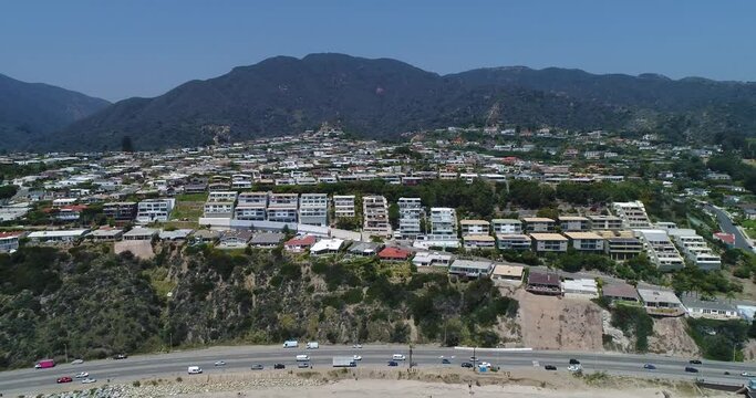 Drone shot what Big Dume Beach with town on the hill at California