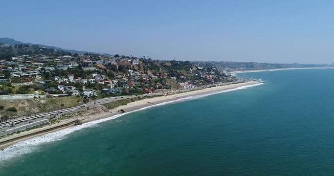 Drone shot what Big Dume Beach with town on the hill at California