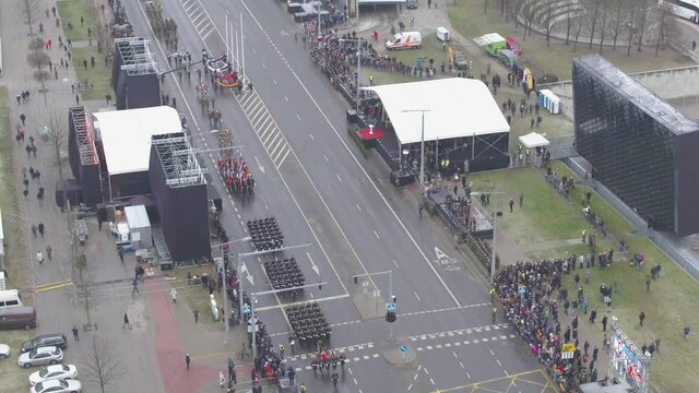 Aerial view of military parade in a middle of a city. Cloudy day.