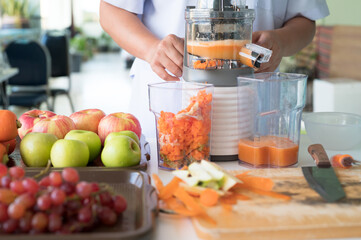 Vegetable and fruit juice healthy with food juicer machine.Woman juicing green and red apple fruits...