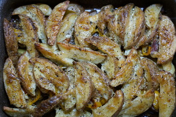 Chicken wings baked in the oven. With a golden crust and spices. They lie in a baking dish.
