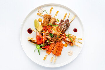 meat and fish kebabs on white plate