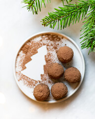 Chocolate truffles and cocoa powder on christmas background