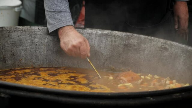 Bograch. Soup with paprika, meat, bean, vegetable, dumpling. Traditional Hungarian Goulash in cauldron. Meal cooked outdoors on an open fire. HD