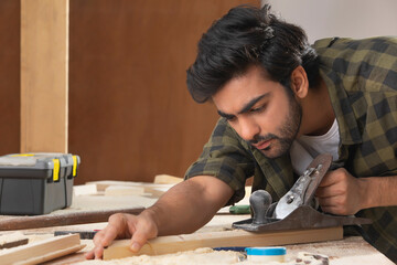 A CARPENTER DILIGENTLY POLISHING WOOD BLOCKS	