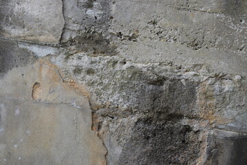 Old grey stone wall with exposed sections of weathered rock