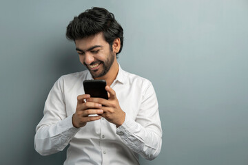 A YOUNG EXECUTIVE LAUGHING WHILE USING MOBILE PHONE DURING VIDEO CONFERENCING	