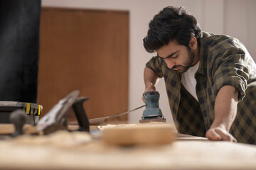 A CARPENTER WORKING WITH EQUIPMENTS TO POLISH WOOD	