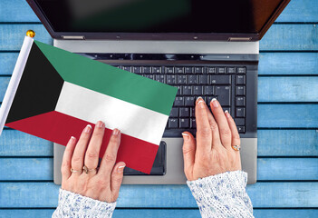 woman hands and flag of Kuwait on computer, laptop keyboard 
