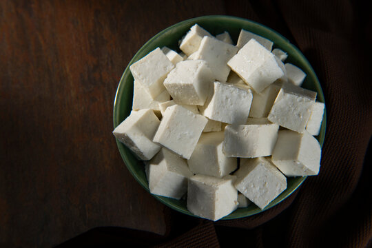 Diced Paneer or cottage cheese in a green bowl	
