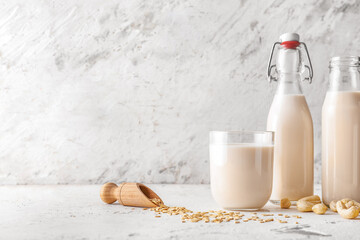 Bottles and glass of different milk on table