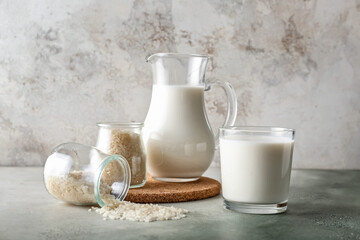 Jug and glasses of rice milk on table
