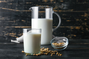 Jug and glass of soy milk on table