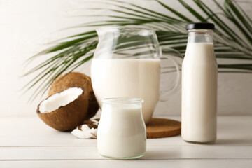 Glassware with tasty coconut milk on table