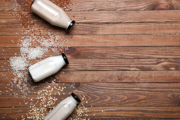 Bottles of different milk on wooden background