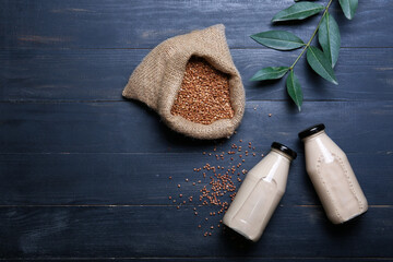 Bottles of buckwheat milk on wooden background