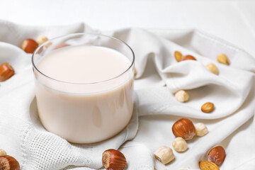 Glass of tasty vegan milk on fabric background