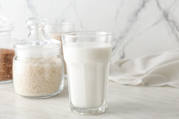 Glass with tasty rice milk on table