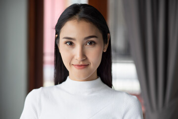 face portrait of happy smiling asian woman, portrait of positive confident happy smiling asian woman smiles in urban indoor environment, young adult Chinese asian woman model