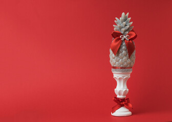 Decorative candle on a stand with red ribbons on a red background.