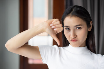 Failed girl pointing thumb down, portrait of unhappy and upset woman pointing rejection thumb down,...